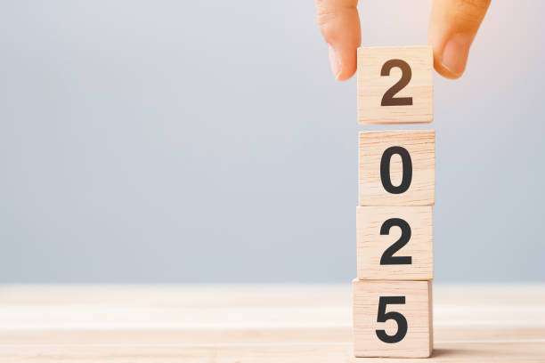istock hand holding wooden cube block with 2025 text on table background. Resolution, plan, review, goal, start and New Year holiday concepts 2153754063