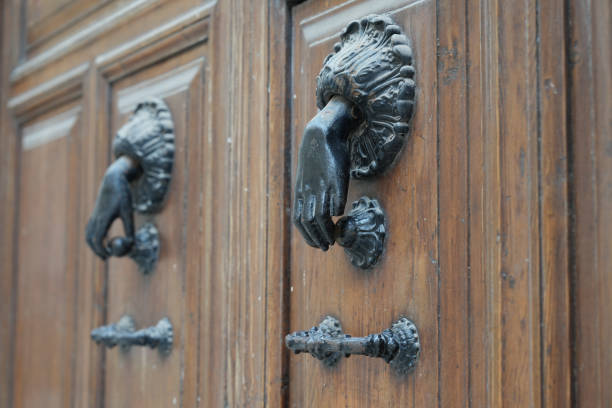Antique hand shaped door knocker on an old wooden door in Lecce Italy