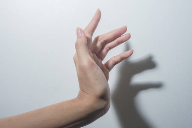 istock Female hand fingers closeup with shadow on white wall background 2153755433