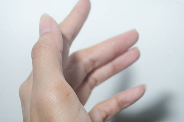 Female hand fingers closeup with shadow on white wall background