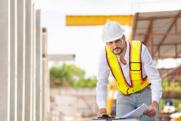 istock Engineer man checking inventory in the precast concrete factory site, Foreman worker with blueprints at construction site 2153760172