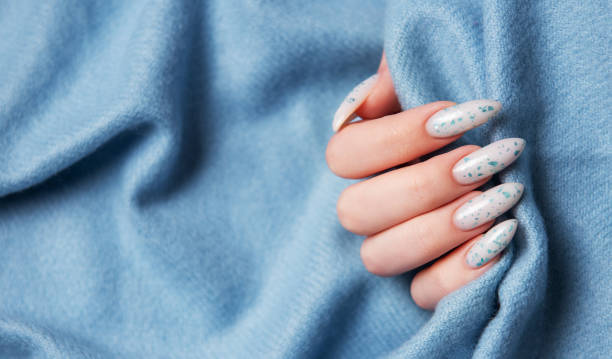 istock Female hands with blue nail design on blue textile background. 2153762333