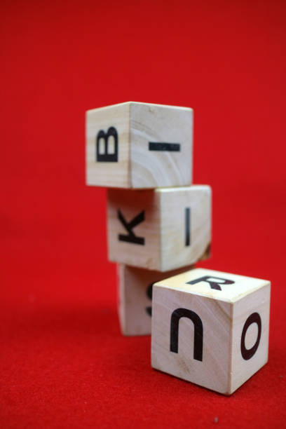 Educational stacking cube toy made of wood with numbers and letters. Red background