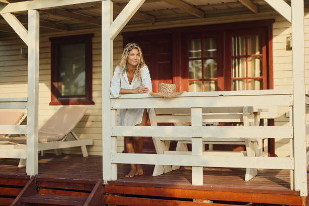 Young woman day dreaming on a house deck in summer day.