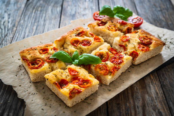 istock Focaccia - roasted mozzarella sandwiches with ham, tomatoes and arugula on black stone plate 2153768770