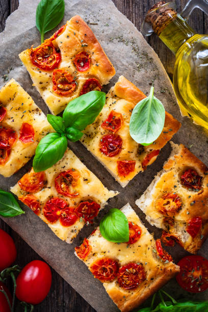 istock Focaccia - roasted mozzarella sandwiches with ham, tomatoes and arugula on black stone plate 2153768867