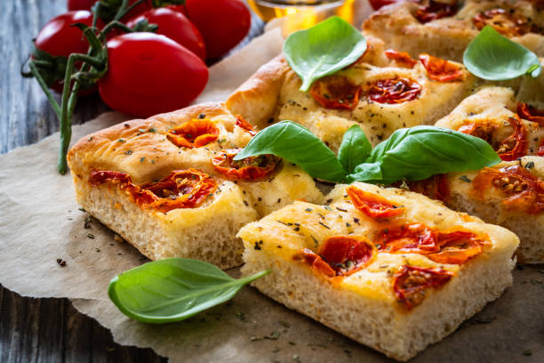 istock Focaccia - roasted mozzarella sandwiches with ham, tomatoes and arugula on black stone plate 2153768888