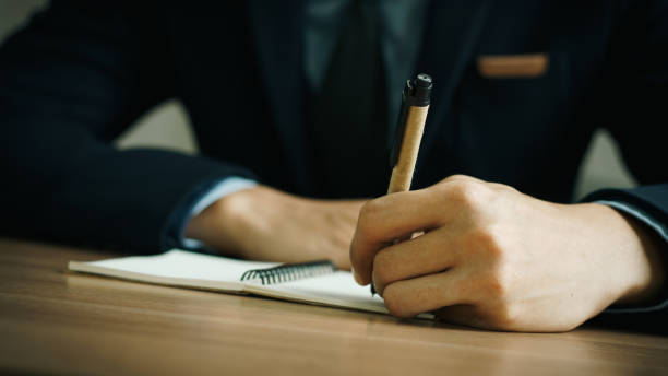 istock businessman working at work table,home office desk background, checklist writing planning investigate enthusiastic concept. Male hand taking notes on the notepad. 2153770383