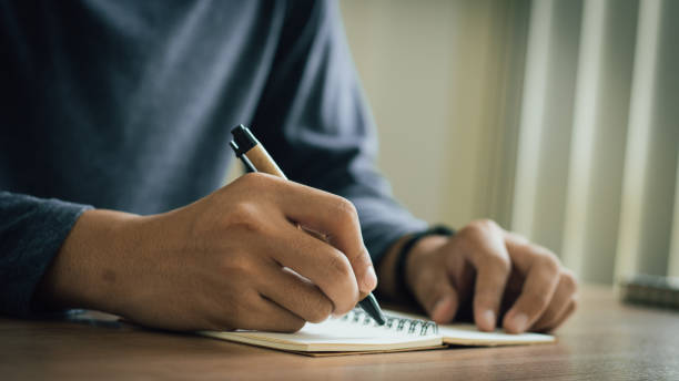 istock businessman working at work table,home office desk background, checklist writing planning investigate enthusiastic concept. Male hand taking notes on the notepad. 2153770434