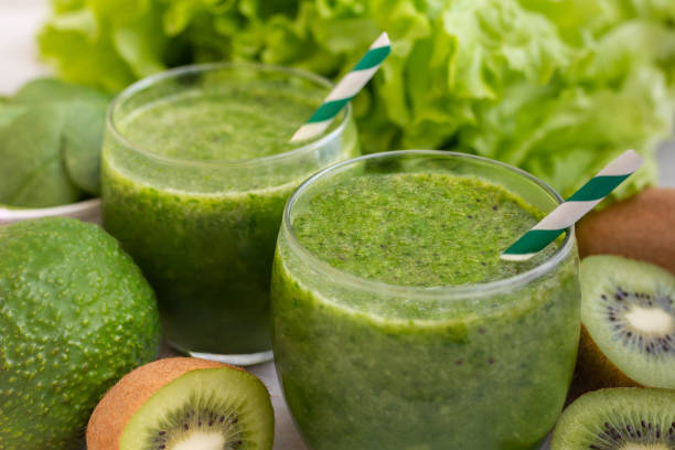 istock Healthy green smoothie with spinach, avocado, lime, pinapple on wooden table. 2153771849
