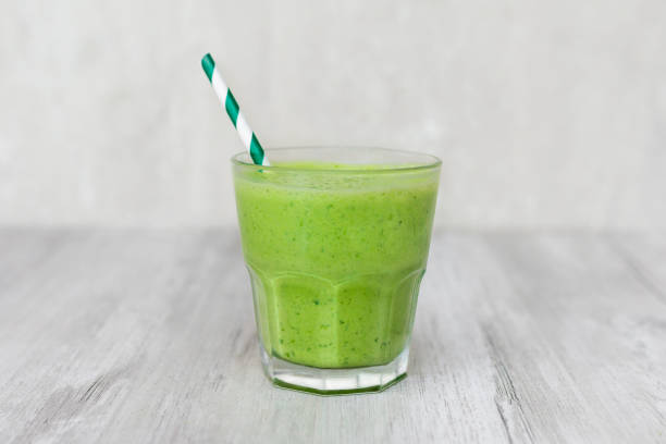 istock Healthy green smoothie with spinach, avocado, lime, pinapple on wooden table. 2153772246