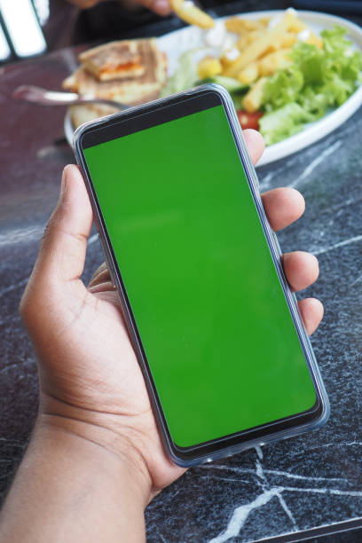 istock young man hand using smart phone with green screen at cafe 2153774225