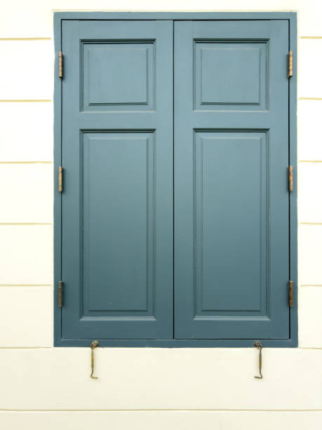istock Closed wooden window on a white building wall 2153774702