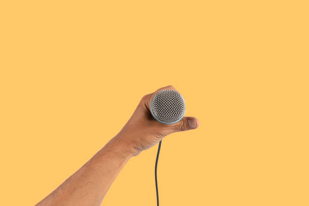 Hand holding a wireless microphone on white background.