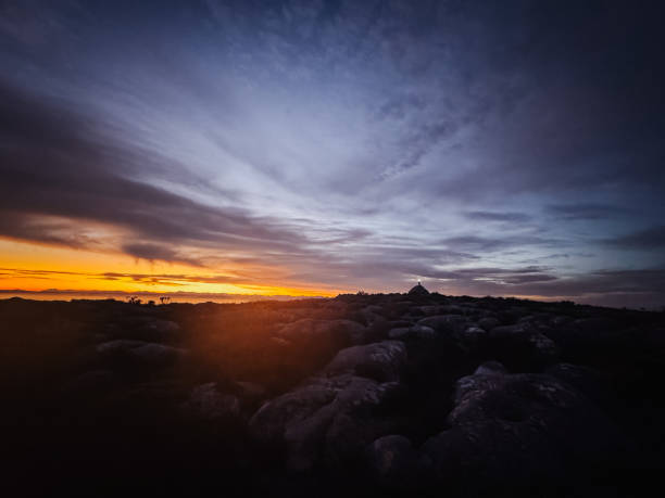 Trail runner hiker silhouette dawn sunrise look at Maclears Beacon Table Mountain summit, Cape Town, South Africa