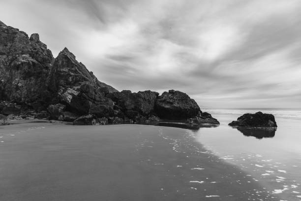istock Rocks on an ocean beach under dark cloudy sky 2153775903