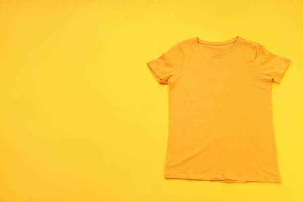 istock Orange t-shirt with space for print on yellow background 2153779556