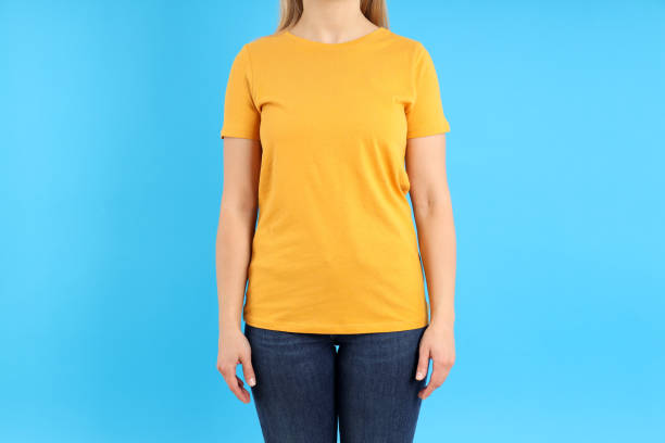 istock Woman in blank orange t-shirt on blue background 2153779708