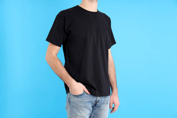 istock Man in blank black t-shirt on blue background 2153779751