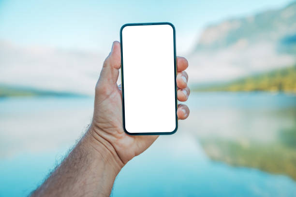 istock Mobile phone mockup, man holding smartphone with blank white screen over the tranquil lake Bohinj water landscape in summer morning 2153779994