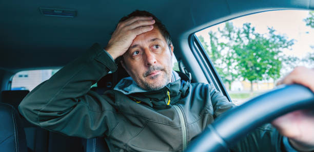 istock Troubled car driver covering his face with hand after traffic accident 2153780034