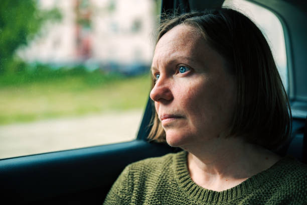 Woman thinking and practicing mindfulness while commuting to work on a taxi vehicle back seat
