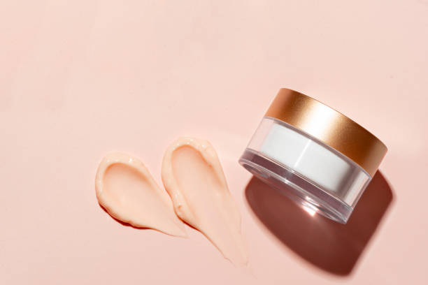Pink peach cosmetic cream sample and jar Pink peach cosmetic cream swatch sample and jar on nude pink background, copy space. Beauty anti ageing creme smear, body lotion, moisturizer smudge swipe. Skincare rich cream or nourishing balm. makeup swipes stock pictures, royalty-free photos & images