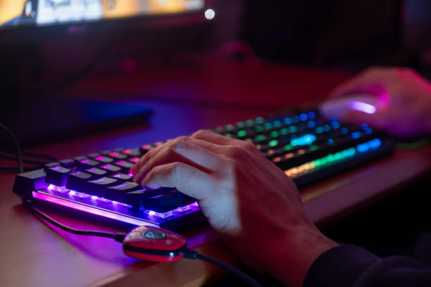 istock Close-up of a gamer's hands on a backlit keyboard, ready for action 2153781034