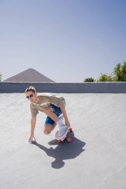 istock A young man skillfully skateboarding down the ramp on a surf skate, showcasing his balance over the board. 2153783601