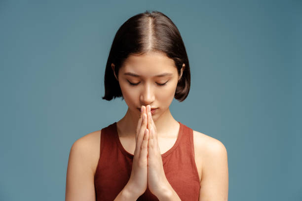 istock Sad woman praying with closed eyes and thinking problems isolated 2153785084
