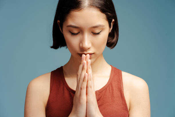istock Upset woman praying with closed eyes and thinking problems isolated 2153785115