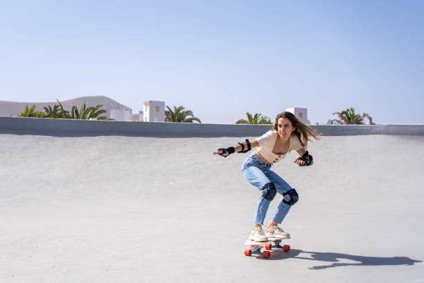 istock Young Woman Riding Skateboard Down Ramp 2153786837