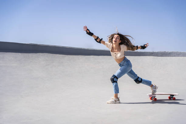 istock Woman falling from skateboard at skate park on sunny day 2153787622