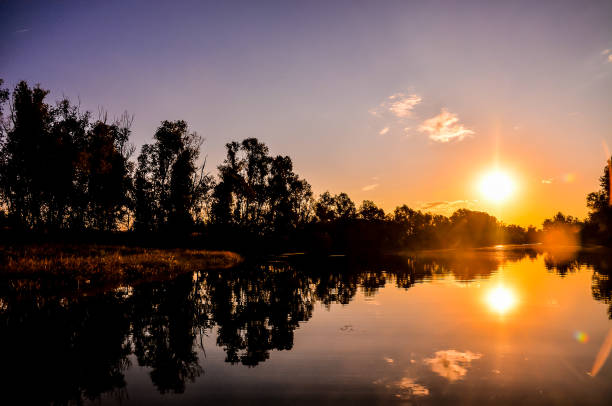 istock A beautiful sunset over a lake with trees in the background 2153787666
