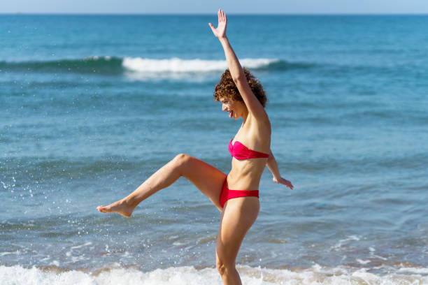 istock Slim woman in bikini walking in sea 2153788080