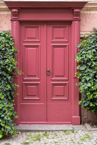 istock Red door at building surrounded by ivy 2153789780