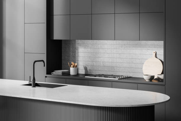 Dark home kitchen interior with bar countertop and sink, stove and kitchenware