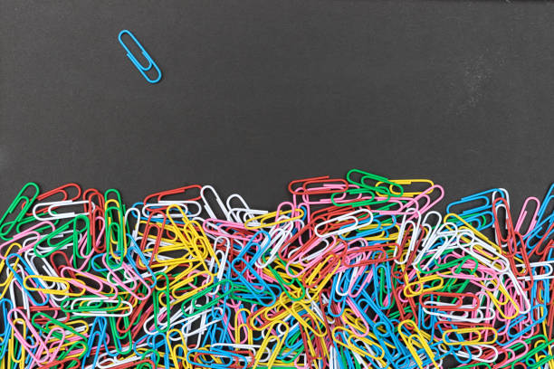 Black background with colorful paper clips and copy space