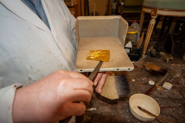 istock Craftsman, restoration. hands with gold leaf 2153792278
