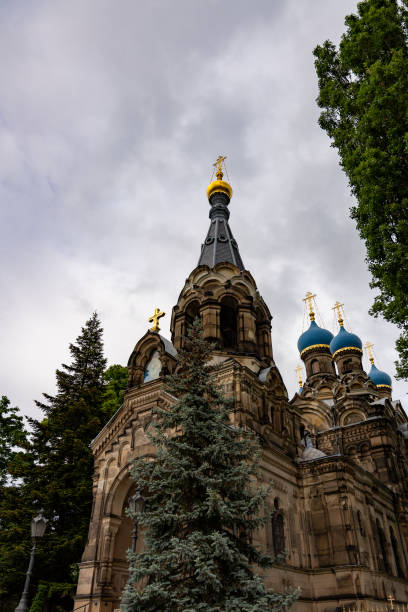 istock A large church with a tall steeple and a small tree in front of it 2153795317