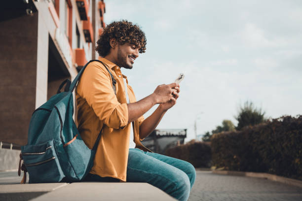 Photo of nice cheerful mexican man exchange student writing comment reading post autumn day outside