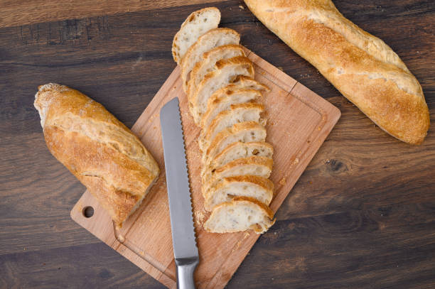 istock Sliced ​​bread for breakfast on a cutting board, a knife lies next to it, top view 2153802993