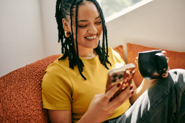 istock Young Woman Relaxing on Couch with Mobile Phone and Coffee 2153803318