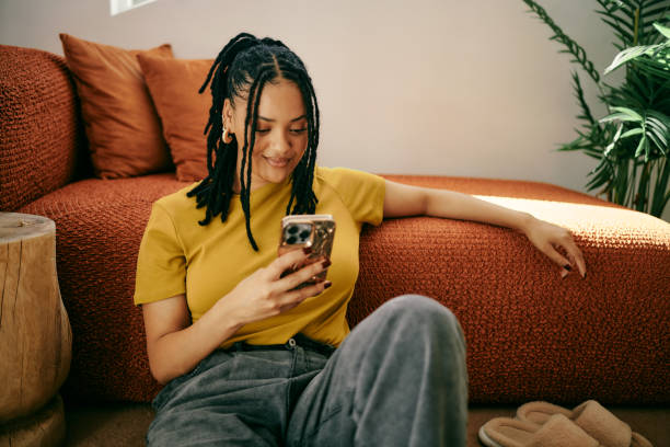 istock Digital Connection: Young Woman Texting on Floor by Couch 2153803340