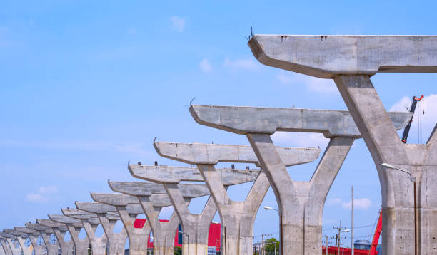 istock Row of large concrete columns structure of elevated expressway on highway in under construction against blue sky background, perspective side view 2153807293