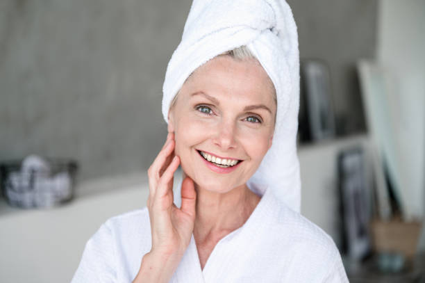 istock Smiling mature woman in bathrobe feeling refreshment after shower 2153808573
