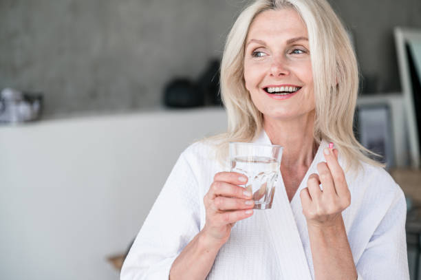 istock 50s old woman taking capsule with Omega 3, nutrition concept 2153808614