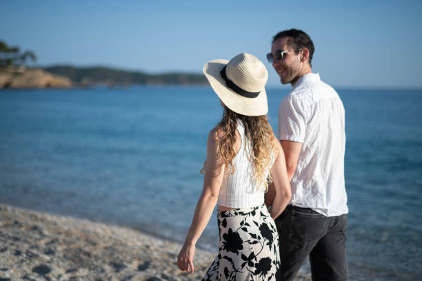 istock Couple in love walking on the beach at sunset. 2153808688