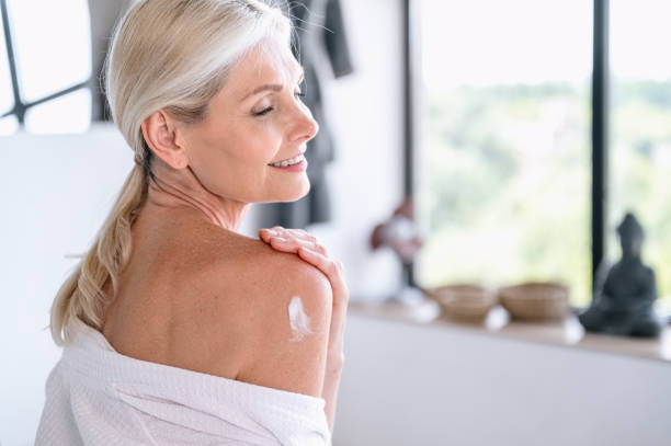 istock Mature woman put anti aging moisturizer cream on shoulder 2153808697