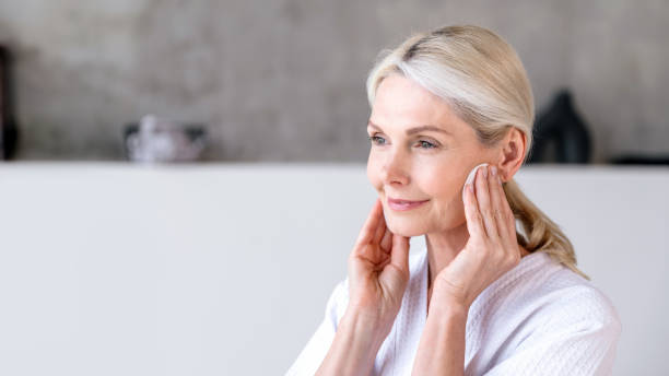 istock Elderly woman do skincare routine, cleansing her face with sponge 2153808708